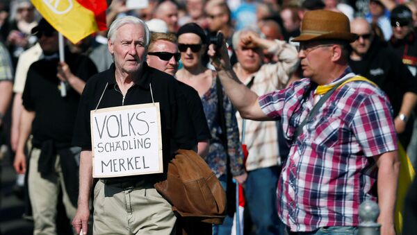 Right-wing protestors demonstrate against refugees, Islam and German Chancellor Angela Merkel in Berlin, Germany, May 7, 2016. The sign reads: Volksschaedling (Enemy of the People) - Sputnik International