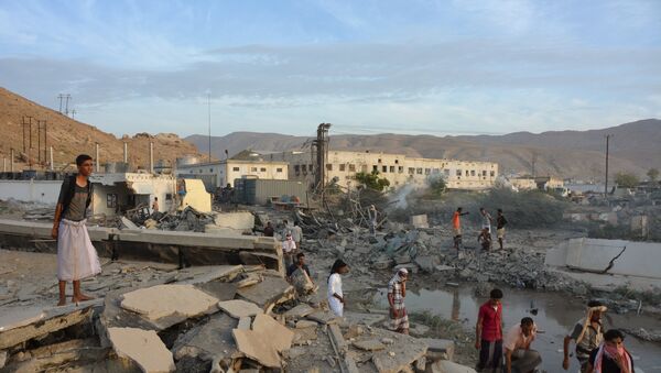 People inspect damage at a site hit by Saudi-led air strikes in the al Qaeda-held port of Mukalla city in southern Yemen April 24, 2016 - Sputnik International
