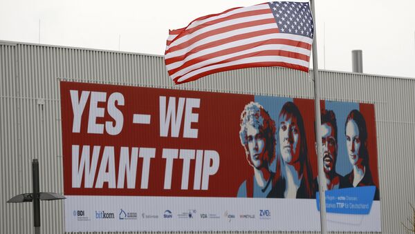 The flag of the USA flutters over a hall of the Hanover Fair decorated with a banner supporting the free trade agreement TTIP (Transatlantic Trade and Investment Partnership) in Hanover, Germany April 25, 2016 - Sputnik International