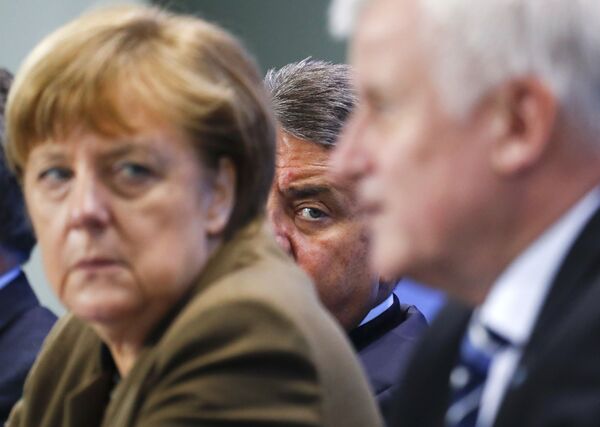 German Economy Minister Siegmar Gabriel (C) peers between Chancellor Angela Merkel and Bavarian state premier and leader of the Christian Social Union (CSU) Horst Seehofer during a news conference at the Chancellery in Berlin, Germany, April 14, 2016. German Economy Minister Siegmar Gabriel (C) peers between Chancellor Angela Merkel and Bavarian state premier and leader of the Christian Social Union (CSU) Horst Seehofer during a news conference at the Chancellery in Berlin, Germany, April 14, 2016. - Sputnik International