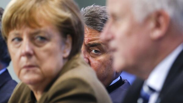 German Economy Minister Siegmar Gabriel (C) peers between Chancellor Angela Merkel and Bavarian state premier and leader of the Christian Social Union (CSU) Horst Seehofer during a news conference at the Chancellery in Berlin, Germany, April 14, 2016. - Sputnik International
