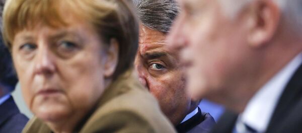 German Economy Minister Siegmar Gabriel (C) peers between Chancellor Angela Merkel and Bavarian state premier and leader of the Christian Social Union (CSU) Horst Seehofer during a news conference at the Chancellery in Berlin, Germany, April 14, 2016. - Sputnik International
