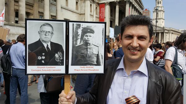 Aleksandr Kandaurov holding portraits of his grandfather and uncle-in-law. Aleksandr Kandaurov holding portraits of his grandfather and uncle-in-law. - Sputnik International