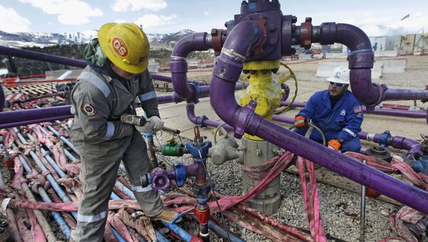 In this March 29, 2013, file photo, workers tend to a well head during a hydraulic fracturing operation outside Rifle, in western Colorado - Sputnik International