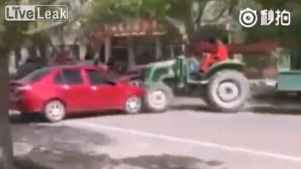 Villager drives trailer tractor to clear illegal street parking - Sputnik International