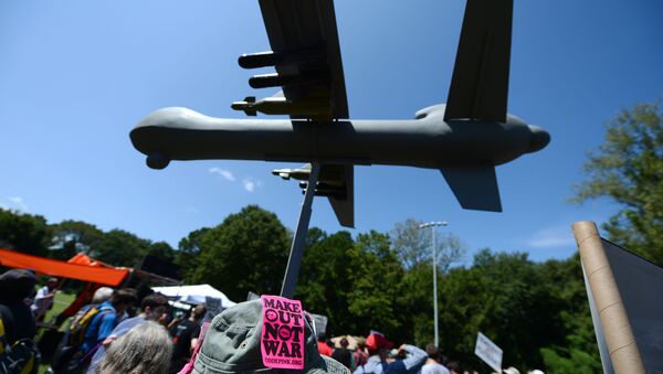 Protesters against the use of drone strikes by the US military hold a model of a drone aircraft during the March On Wall Street South rally in Charlotte, North Carolina on September 2, 2012. - Sputnik International