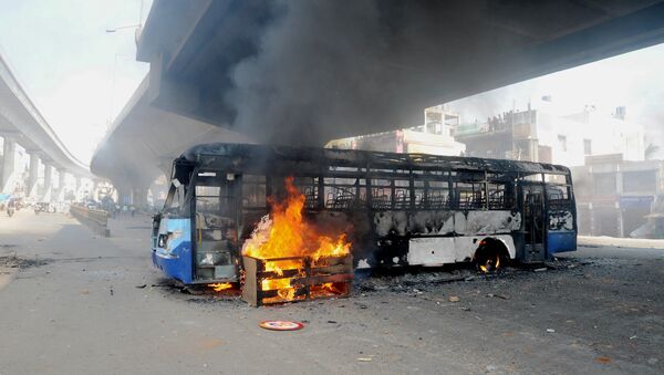 A bus burns underneath an flyover following a protest by Indian garment factory workers in Bangalore on April 19, 2016 - Sputnik International