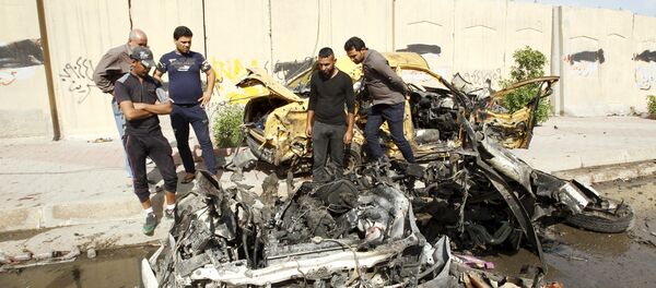 Iraqi men inspect the site of car bomb attack in Baghdad, Iraq (File) - Sputnik International