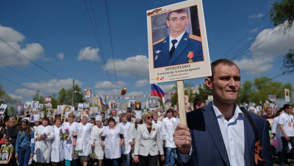 A participant carries a photo of Hero of Russia Alexander Prokhorenko killed in Syria, during the Immortal Regiment march on the 71st anniversary of Victory in WWII in Orenburg - Sputnik International