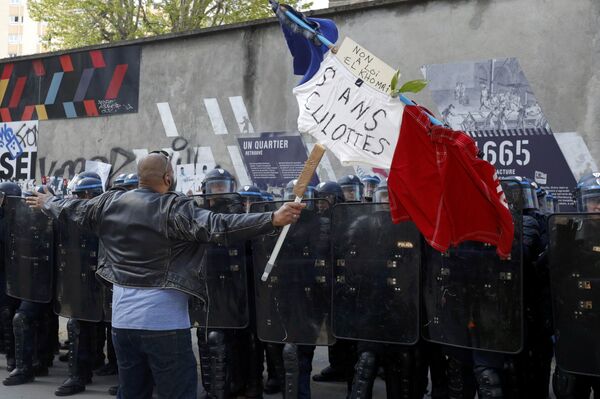 A man holds a French flag with the message, No to the El Khomri law in front of a line of French riot police during a protest against the French labour law proposal during the May Day labour union march in Paris, France, May 1, 2016. - Sputnik International