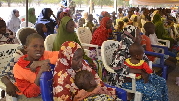 In this Feb. 12, 2016, file photo, woman and children detained by Nigeria army who have no links to Boko Haram sit under a canopy before their release at the Giwa military barracks in Maiduguri, Nigeria. - Sputnik International