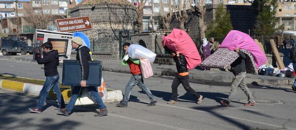 Kurds leave their houses with their belongings after new curfews were imposed in the Sur district of Diyarbakir on January 27, 2016. Kurds leave their houses with their belongings after new curfews were imposed in the Sur district of Diyarbakir on January 27, 2016. - Sputnik International