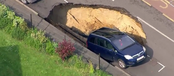 Car teeters on the edge of giant sinkhole, London Car teeters on the edge of giant sinkhole, London - Sputnik International