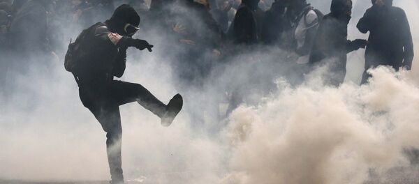 A protester kicks back a teargas grenade during a demonstration against French labour law reform in Paris, France, May 12, 2016. - Sputnik International