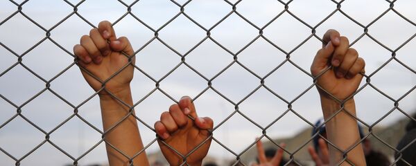 Syrian refugee children chant slogans behind a fence at the Nizip refugee camp in Gaziantep province, southeastern Turkey. - Sputnik International