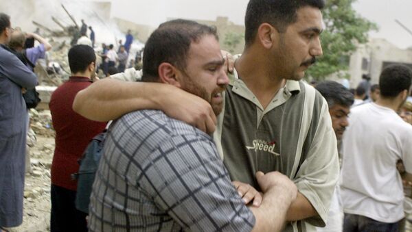 An Iraqi man (L) who lost nine members of his family in afternoon US-British coalition bombing of Baghdad's al-Mansur neighborhood grieves 07 April 2003 in the arms of a friend. - Sputnik International