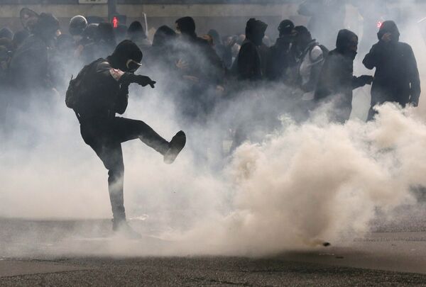 A protester kicks back a teargas grenade during a demonstration against French labour law reform in Paris, France, May 12, 2016. - Sputnik International