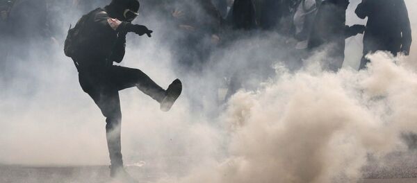 A protester kicks back a teargas grenade during a demonstration against French labour law reform in Paris, France, May 12, 2016. - Sputnik International