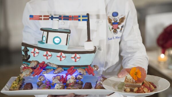 White House pastry chef Susie Morrison holds a dessert featuring a handcrafted fishing boat surrounded by miniature pastries during a press preview of a State Dinner in honor of the Nordic countries, including Sweden, Norway, Finland, Denmark and Iceland, in the State Dining Room of the White House in Washington, DC, May 12, 2016. - Sputnik International