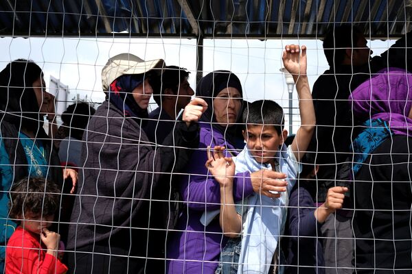 People queue for free food at a makeshift camp for migrants and refugees at the Greek-Macedonian border near the village of Idomeni, Greece, May 11, 2016. - Sputnik International