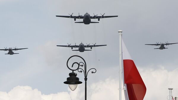 Polish Air Force C-130 Hercules aircraft fly over Poland's national flag during a military parade. - Sputnik International