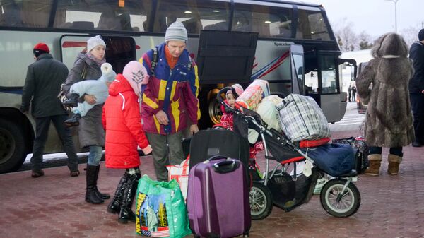 Refugees from Ukraine leave a bus at the airport of northeastern Ukrainian city of Kharkiv - Sputnik International