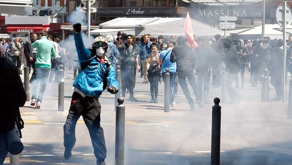 A masked demonstrator throws a tear gas canister during a clash with police, after a demonstration in Marseille, southern France, Thursday, May 12, 2016 - Sputnik International