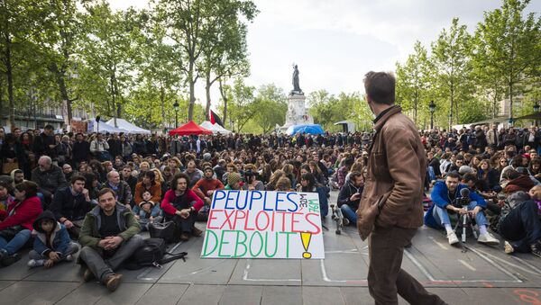 Protester Jean-Baptiste Redde aka Voltuan holds a placard reading 'Exploited people stand up!' as people gather for the general assembly of the Nuit Debout (Up All Night) movement against the French government's proposed labour reforms at the Place de la Republique in Paris on May 15, 2016 - Sputnik International