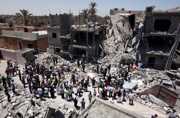 Libyans gather next to the rubble of buildings the Libyan authorities said were damaged by airstrikes on Tripoli's residential district of Arada (File) Libyans gather next to the rubble of buildings the Libyan authorities said were damaged by airstrikes on Tripoli's residential district of Arada (File) - Sputnik International