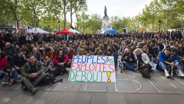 A protester holds a placard reading 'Exploited people stand up!' as people gather for the general assembly of the Nuit Debout movement in Paris on May 15, 2016 - Sputnik International