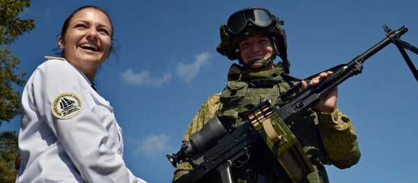 A visitor stands next to a marine demonstrating a Pecheneg machine gun during an exhibition of armaments and special equipment held as part of the Innovation Day at the Eastern Military District in Vladivostok A visitor stands next to a marine demonstrating a Pecheneg machine gun during an exhibition of armaments and special equipment held as part of the Innovation Day at the Eastern Military District in Vladivostok - Sputnik International