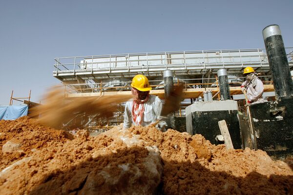 Asian labourers work at the site of Saudi Aramco's (the national oil company) central oil processing facility in al-Khurais, still under construction in the Saudi Arabian desert, 160 kms east of the capital Riyadh (File) - Sputnik International
