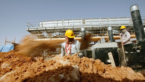 Asian labourers work at the site of Saudi Aramco's (the national oil company) central oil processing facility in al-Khurais, still under construction in the Saudi Arabian desert, 160 kms east of the capital Riyadh (File) - Sputnik International