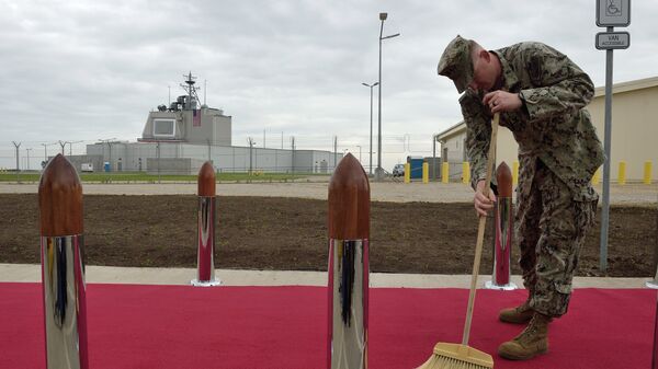 US Army personnel cleans the red carpet ahead an inauguration ceremony of the US anti-missile station Aegis Ashore Romania (in the background) at the military base in Deveselu, Romania on May 12, 2016 - Sputnik International