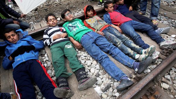 Boys lay on a railway track during a protest at a makeshift camp for refugees and migrants at the Greek-Macedonian border near the village of Idomeni, Greece, May 5, 2016. - Sputnik International