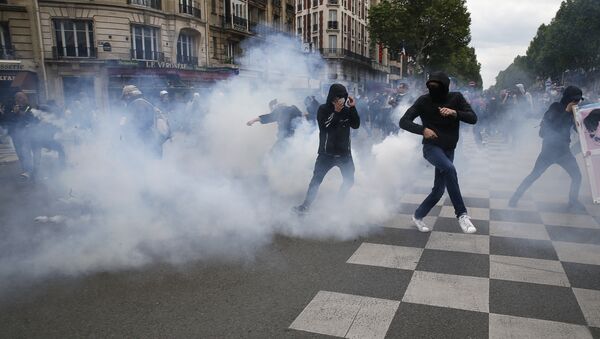 Protesters run from a tear gas canister during clashes with police at a demonstration after the French government used the constitution's Article 49,3 to bypass parliament and force through a controversial labour reform bill, on May 17, 2016, in Paris - Sputnik International