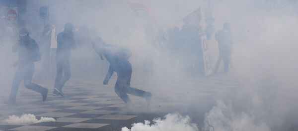 Protesters run from tear gas canisters during clashes with police at a demonstration after the French government used the constitution's Article 49,3 to bypass parliament and force through a controversial labour reform bill, on May 17, 2016, in Paris Protesters run from tear gas canisters during clashes with police at a demonstration after the French government used the constitution's Article 49,3 to bypass parliament and force through a controversial labour reform bill, on May 17, 2016, in Paris - Sputnik International