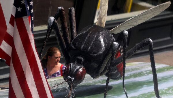 A woman walks past a giant fake mosquito placed on top of a bus shelter as part of an awareness campaign about the Zika virus in Chicago, Illinois, United States, May 16, 2016 - Sputnik International