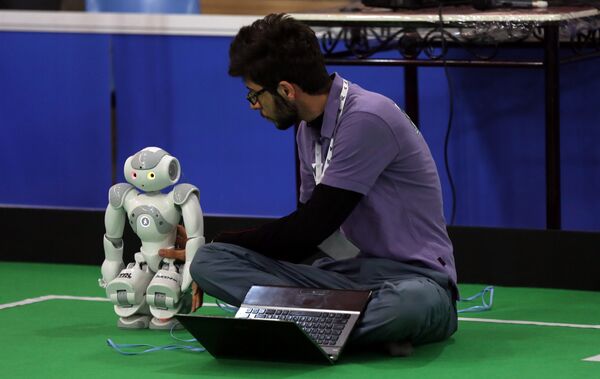 An Iranian sudent from Iran's Azad University of Qazvin checks a robot during the RoboCup Iran Open 2015, in Tehran, on April 8, 2015 - Sputnik International