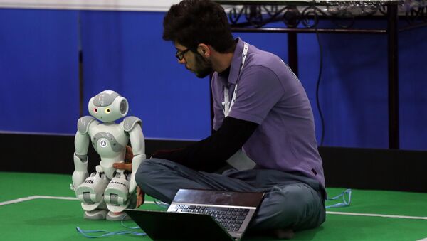 An Iranian sudent from Iran's Azad University of Qazvin checks a robot during the RoboCup Iran Open 2015, in Tehran, on April 8, 2015 - Sputnik International