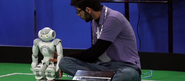 An Iranian sudent from Iran's Azad University of Qazvin checks a robot during the RoboCup Iran Open 2015, in Tehran, on April 8, 2015 - Sputnik International