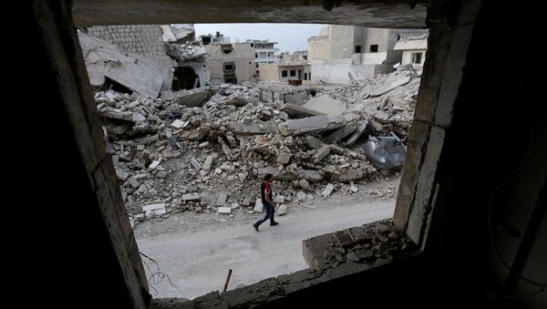 A man walks past damaged buildings in the rebel-controlled area of Maaret al-Numan town in Idlib province, Syria, May 15, 2016 - Sputnik International
