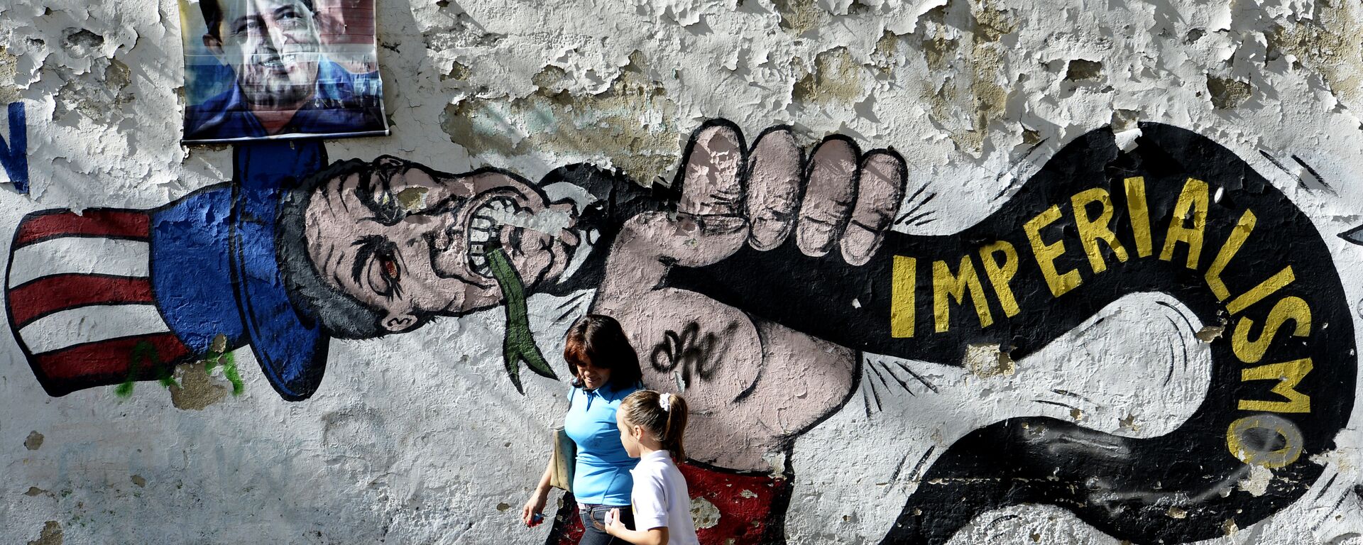 A woman and a girl walk in front of a graffiti of US Uncle Sam in Caracas on March 11, 2015 - Sputnik International, 1920, 05.08.2024