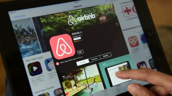 A woman browses the site of US home sharing giant Airbnb on a tablet in Berlin on April 28, 2016.  - Sputnik International