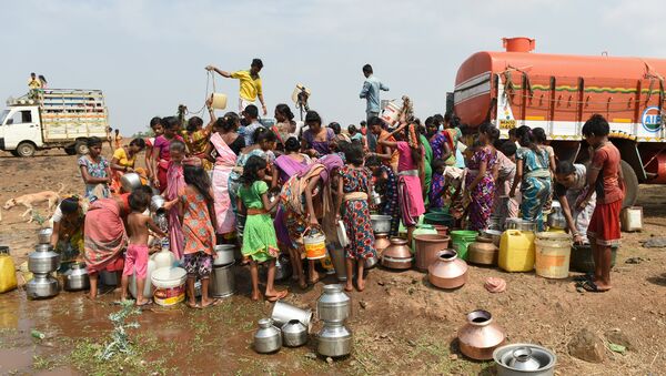 Indian villagers fill containers with water after a tanker made its daily delivery at Shahapur, some 130 km southwest of Mumbai, on May 13, 2016 - Sputnik International