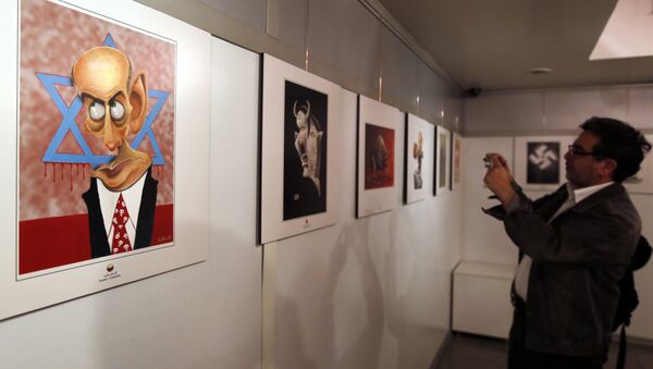 An Iranian man takes a photo of an anti-Israel cartoon displayed at the second international exhibition of drawing and cartoons on the Holocaust in Tehran on May 14, 2016 - Sputnik International