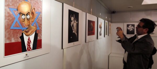 An Iranian man takes a photo of an anti-Israel cartoon displayed at the second international exhibition of drawing and cartoons on the Holocaust in Tehran on May 14, 2016 - Sputnik International
