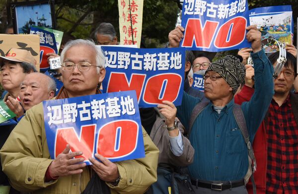 People hold banners as they listen to a speaker during a rally against a new US military base in Okinawa, Japan's nouthernmost prefecture (file) - Sputnik International