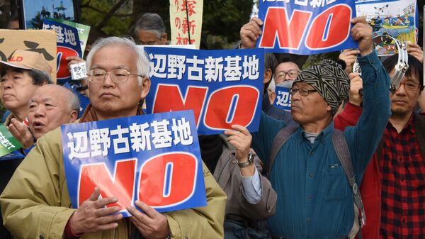 People hold banners as they listen to a speaker during a rally against a new US military base in Okinawa, Japan's nouthernmost prefecture (file) - Sputnik International