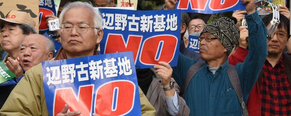 People hold banners as they listen to a speaker during a rally against a new US military base in Okinawa, Japan's nouthernmost prefecture (file) People hold banners as they listen to a speaker during a rally against a new US military base in Okinawa, Japan's nouthernmost prefecture (file) - Sputnik International